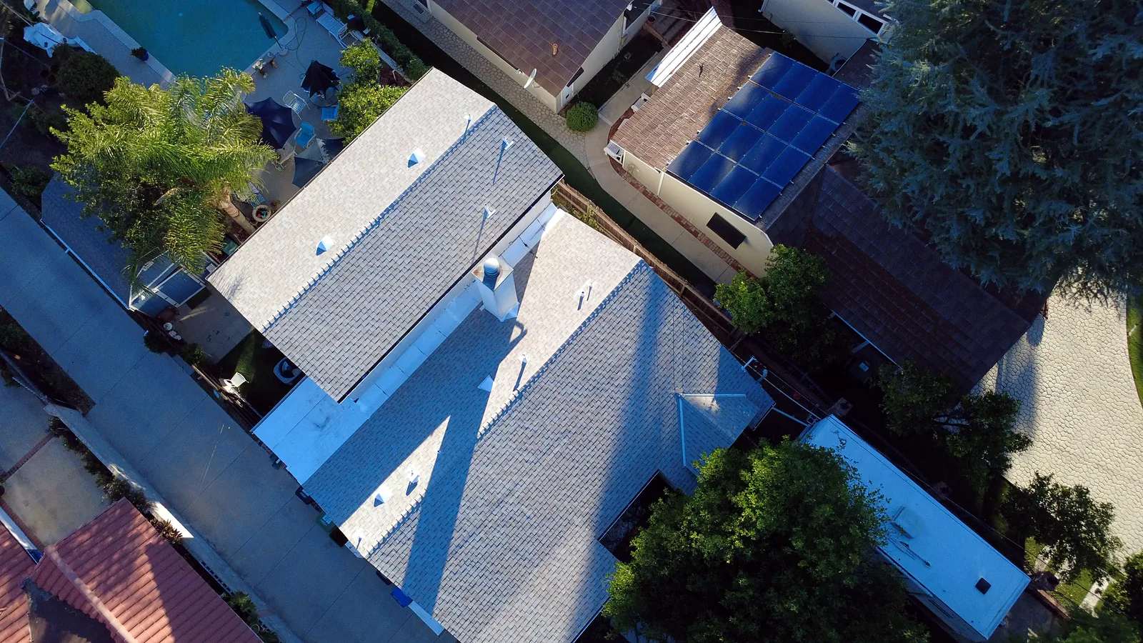 Top-down drone photo of a light gray shingle roof replacement in Woodland Hills, CA