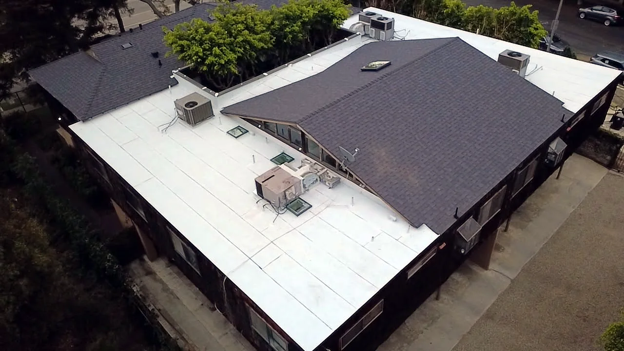 Shingle-to-flat-roof transitions and flashed skylights on a Barrington-area multi-unit roof
